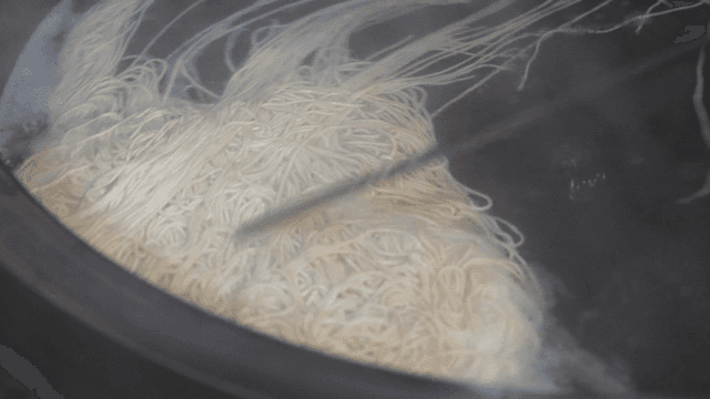 Buckwheat noodles stirred and boiling in a large pot