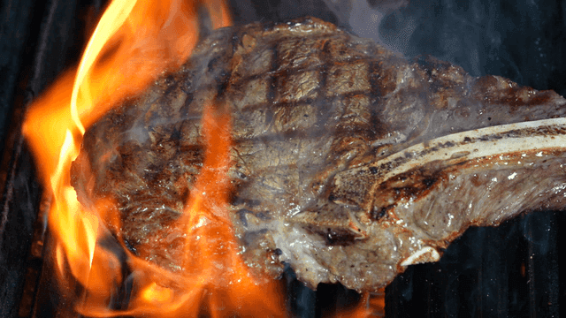 Grilling steak over open flames
