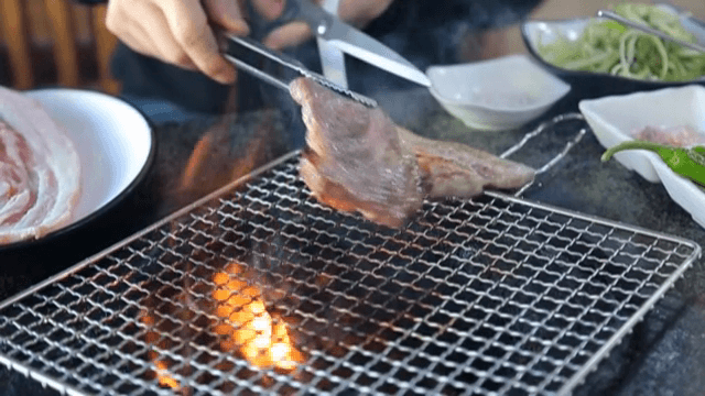 바베큐 그릴 위에서 삼겹살 자르기