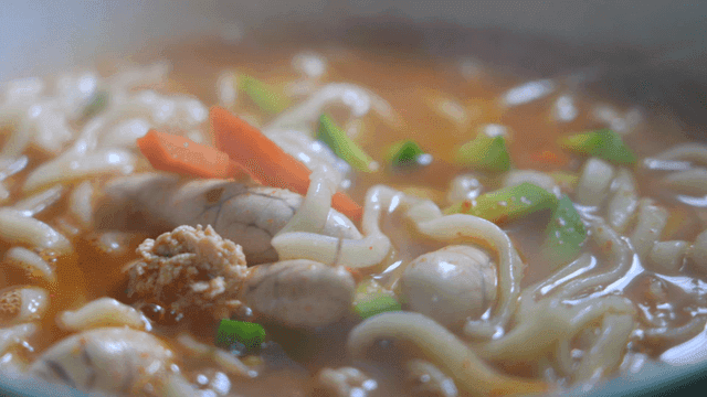 Spicy seafood kalguksu with vegetables and fish roe