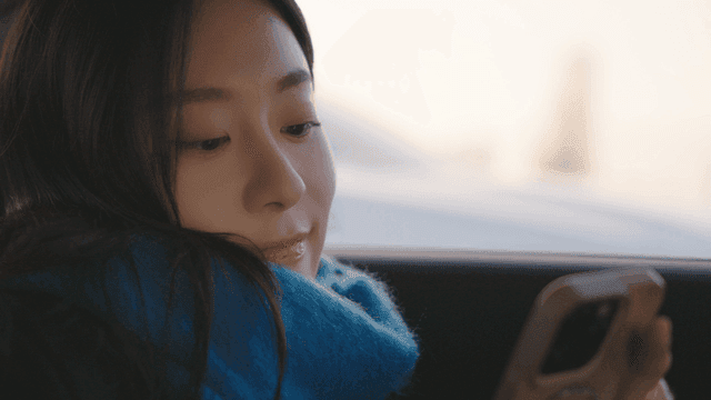 Woman looking at her phone in a taxi