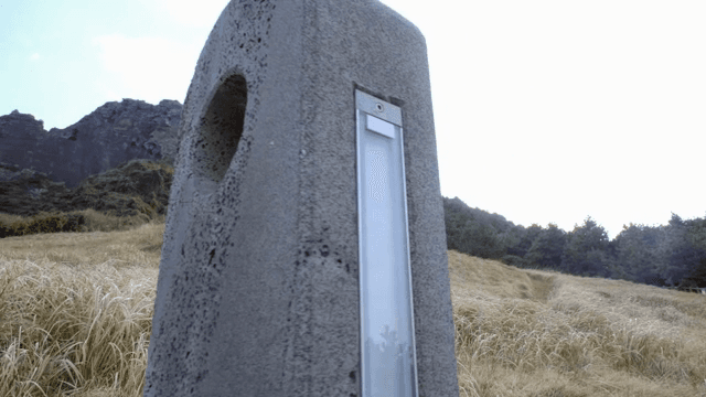 A stone sculpture in a grassy field