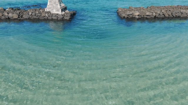 Clear turquoise sea with rocky breakwater