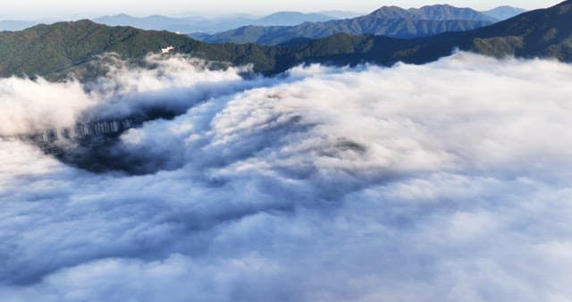 Clouds covering a city with mountains