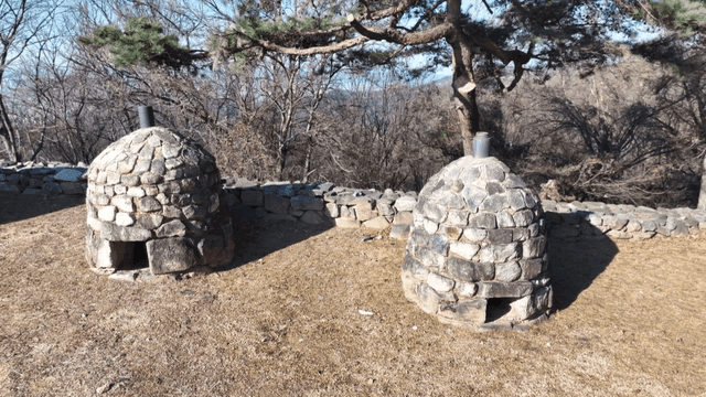 Stone beacon tower in clearing in forest