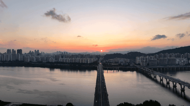 Bridge leading to city at sunset