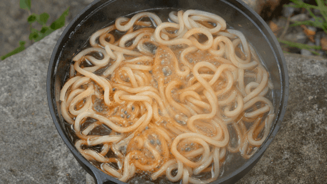 야외에서 냄비에 끓는 우동