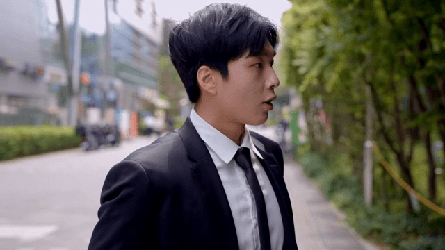 머리 정리를 한 후에 길을 걸어가는 직장인 남성