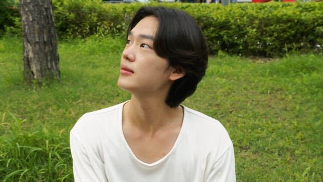 Young man smiling in a green park