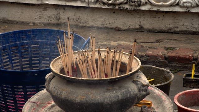 Tourist putting a smoky incense stick into a brazier