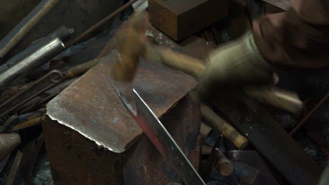 Craftsman forging a metal blade