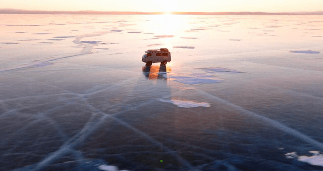 해질녘 얼어붙은 호수 위를 달리는 밴