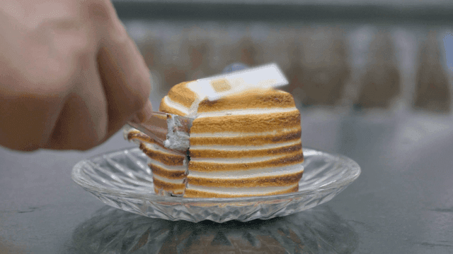 A layered dessert being sliced with a fork