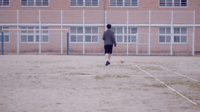 학교 운동장에서 축구하는 사람