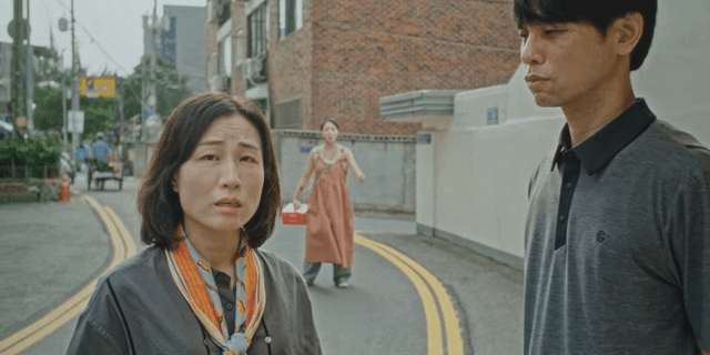 거리에서 대화하는 남녀 뒤에서 소리치는 여성