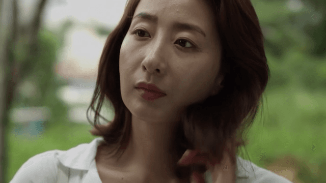 생각에 잠긴 여성이 밖에 서 있는 모습