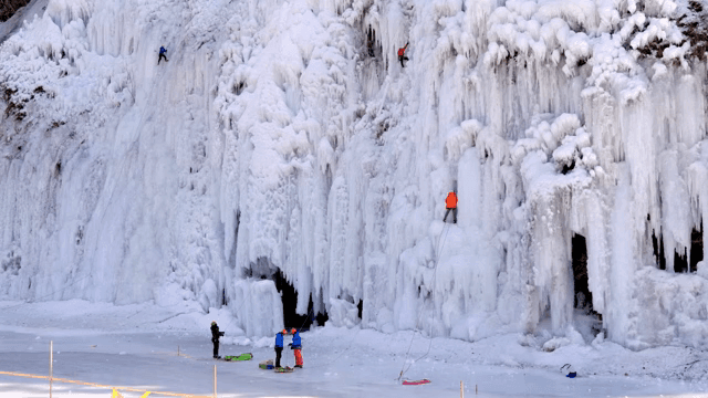 얼어붙은 폭포를 오르는 아이스 클라이머