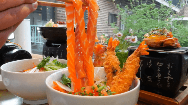 젓가락으로 들어올린 긴 연어회