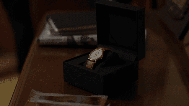 A watch being placed in a box on a table