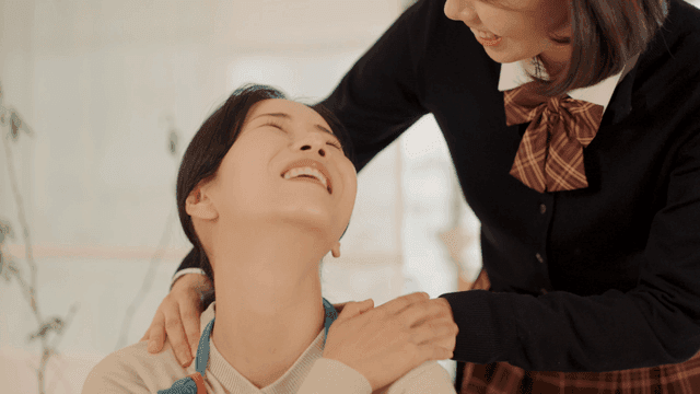 Daughter giving her mother shoulder massage