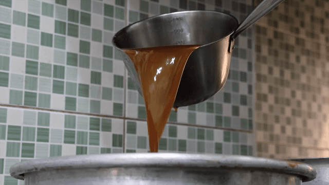 주방에서 냄비에 소스를 붓는 장면