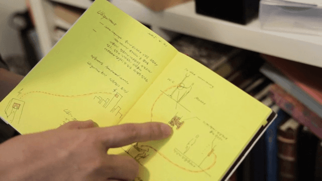 노트북의 스케치를 가리키는 사람