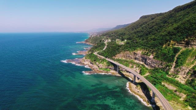 Coastal Road Along a Lush Green Hillside