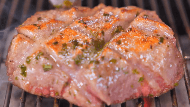 Grilling juicy steak on a barbecue