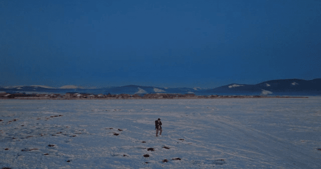 새벽에 눈 덮인 들판을 걷는 사람