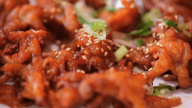 Spicy grilled chicken feet on a white plate