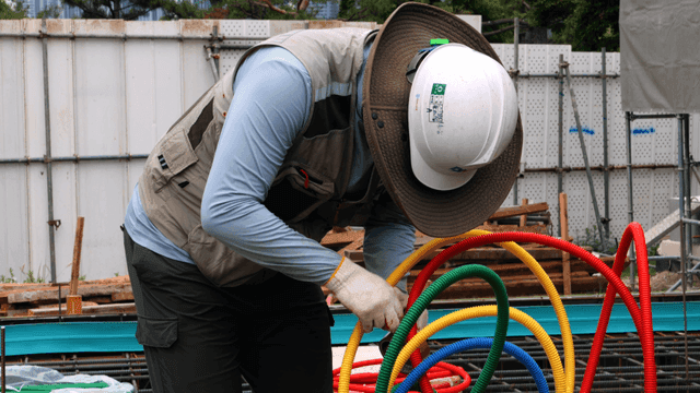Construction worker organizing cables
