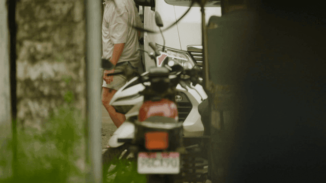 A person exiting a van in a narrow alley
