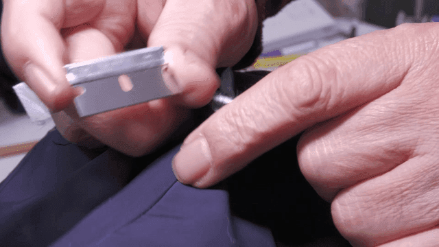 면도날로 자켓을 수선하는 손