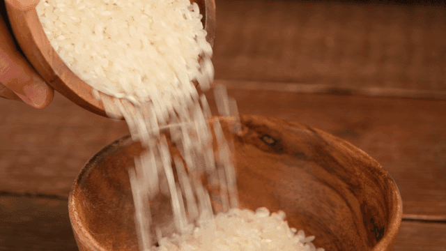 Pouring rice into a wooden bowl