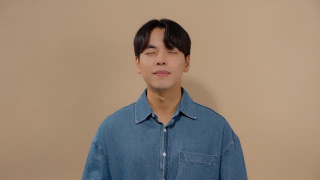 Man meditating with his eyes closed and a satisfied smile on his face