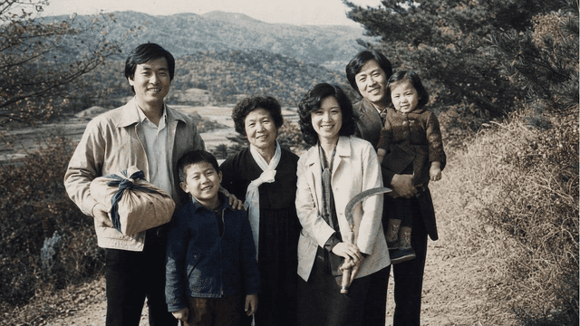 Rural scene from 70s, family out to tend to graves.