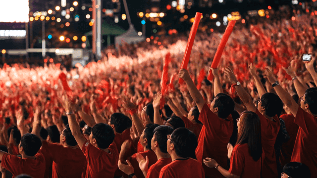 Large crowd cheering at night event