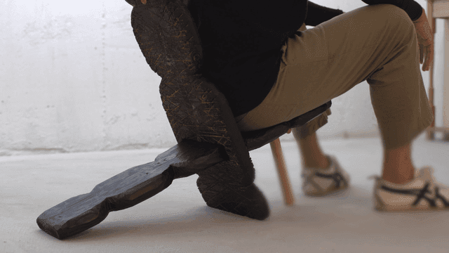 독특한 나무 의자에 앉아 있는 사람