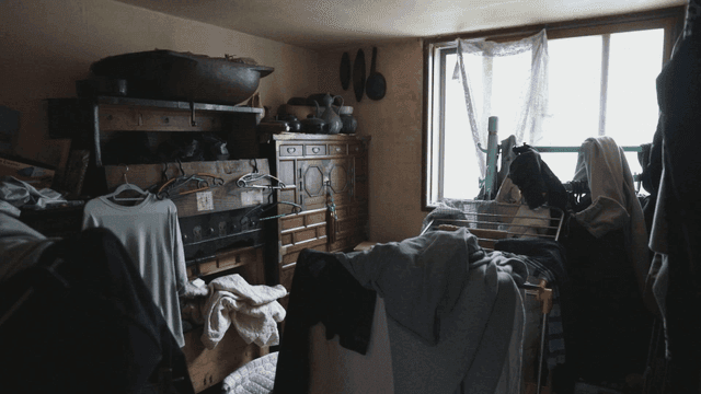 Cluttered room with clothes and furniture