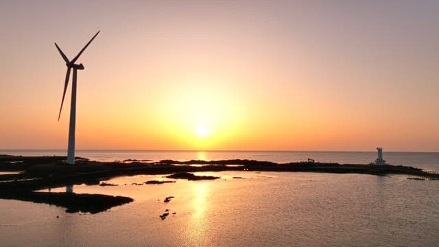 바다 위의 풍력 터빈과 일몰