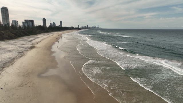 Serene Beachfront with Distant City Skyline