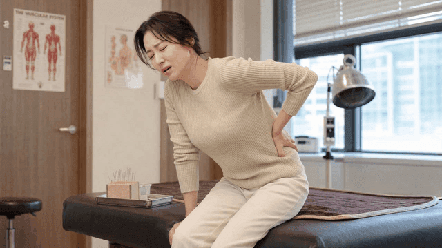 Female patient with back pain at acupuncture clinic