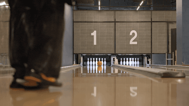 A person bowling in an indoor alley