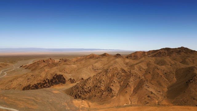 Winding road through a vast desert landscape