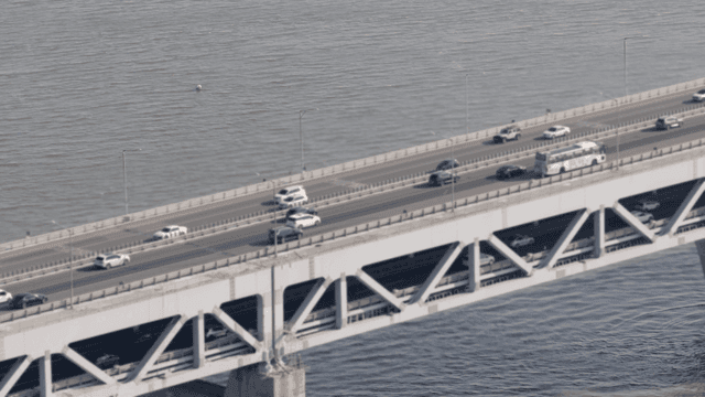 강 위의 큰 다리를 건너는 차량들