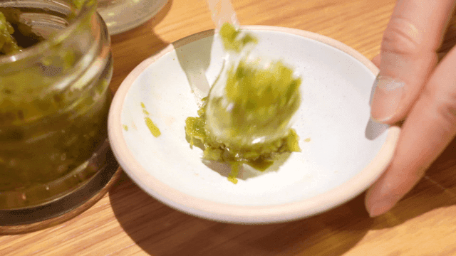Sight of placing green chopped chili seasoning on plate