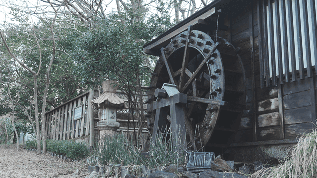 Traditional waterwheel by a wooden house