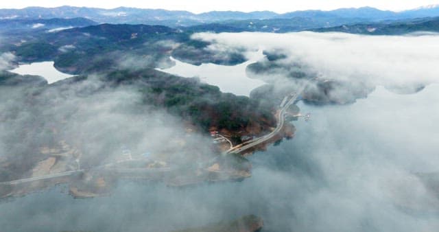 Misty Lake Amidst Lush Mountains