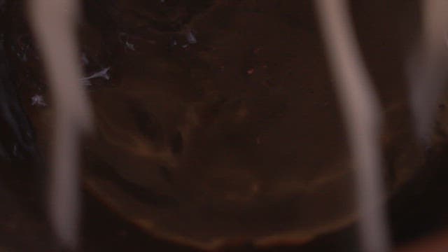 Hands preparing boiled noodles in a bowl