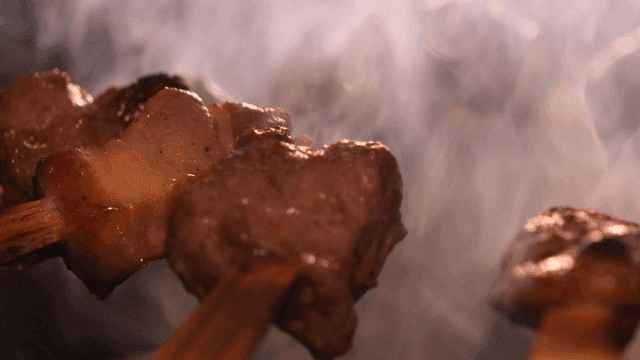 Grilled meat skewers with rising smoke